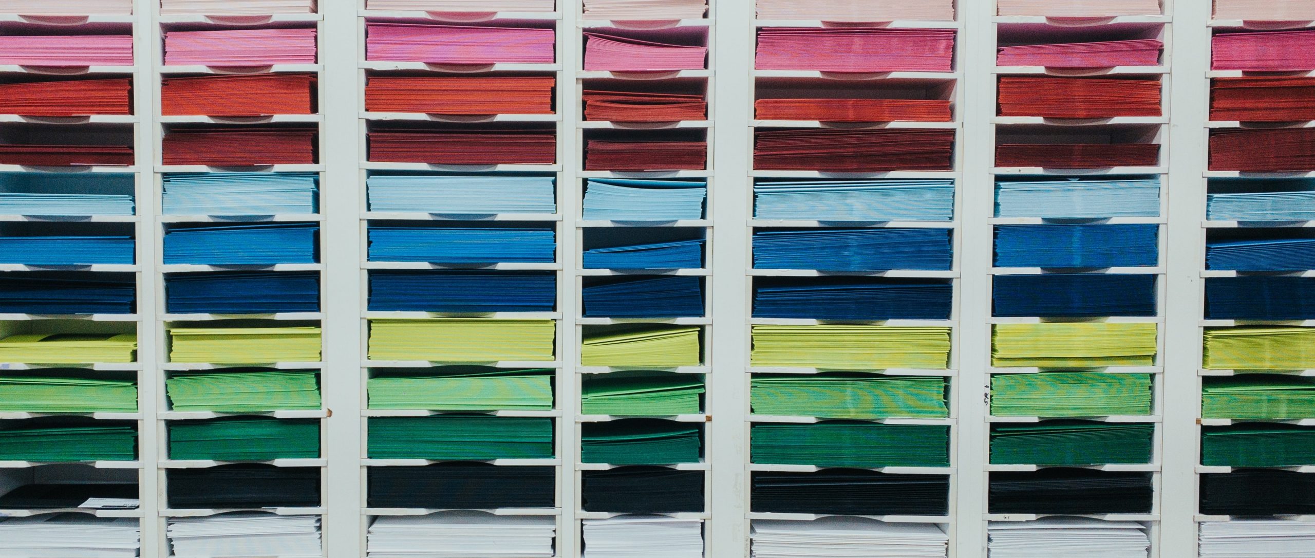Photo of a bookcase full of multicoloured paper